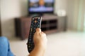 Woman sitting watching tv changing channel with remote Royalty Free Stock Photo