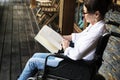 A woman sitting on a wheelchair and reading Royalty Free Stock Photo