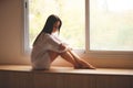 woman sitting on the window sill Royalty Free Stock Photo