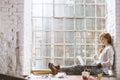 Woman sitting on windowsill with notebook Royalty Free Stock Photo