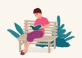 Woman sitting on wooden bench while concentrated reading a book