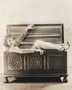 Woman sitting in wooden chest