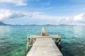 Woman sitting on a wooden pier near the sea Royalty Free Stock Photo