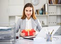 Woman sitting at work and receiving present Royalty Free Stock Photo