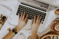 Woman sitting and working with her laptop in bed Royalty Free Stock Photo