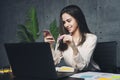 Girl sitting at workplace and communicating in social network using smartphone. Young executive sending text message on mobile