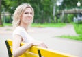 Woman is sitting on the yellow bench in the park Royalty Free Stock Photo