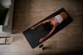 High angle view of young woman sitting on yoga mat doing stretching exercise Royalty Free Stock Photo