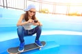 Woman skateboarder sit on skatepark stairs listening music Royalty Free Stock Photo