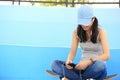 Woman skateboarder sit on skatepark stairs listening music Royalty Free Stock Photo