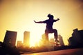 Woman skateboarder skateboarding at sunrise city