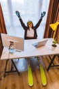 woman in ski equipment working on laptop in office