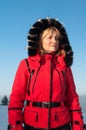 Woman skier in the mountains in red winter jacket