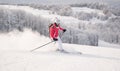 Young woman skier skiing fast downhill on ski slope