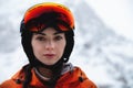 Woman skier on the slope of a mountain resort. Portrait of a young woman smiling in ski equipment, goggles and a helmet Royalty Free Stock Photo