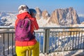 Woman skier wearing a helmet and looking through coin operated binoculars towards Sassolungo Saslonch, Langkofel peak Royalty Free Stock Photo