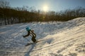 Woman skiing downhill in rays of setting sun Royalty Free Stock Photo