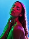 Woman skincare, glowing or neon lighting on isolated blue background and hands on neck, body or skin. Beauty model