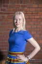 Woman in skirt posing before brick wall