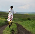 Woman in skirt running on a countryside road Royalty Free Stock Photo