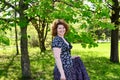 Woman in skirt standing in park near the chestnut