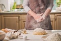 Woman slap his hands above dough closeup. Baker finishing his bakery, shake flour from his hands, free space for text.