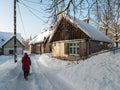 Woman with sled walking along the street. Kuldiga old town with historical houses in snowy winter day, Latvia Royalty Free Stock Photo