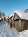 Woman with sled walking along the street. Kuldiga old town with historical houses in snowy winter day, Latvia Royalty Free Stock Photo