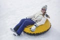 Woman sledding down a hill on a snow tube