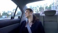 Woman sleeping on back seat taxi, exhausted after stressful workday, burnout