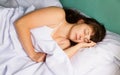 Woman sleeping on bed in bedroom