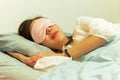 Woman sleeping on bed with eye mask on. Royalty Free Stock Photo