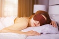 Woman sleeping on bed with eye mask in bedroom with soft light Royalty Free Stock Photo