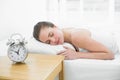 Woman sleeping in bed with focus on alarm clock Royalty Free Stock Photo