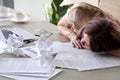 Woman sleeping on desk covered crumpled papers Royalty Free Stock Photo