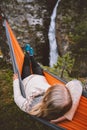 Woman sleeping in hammock with waterfall view in forest outdoor summer vacation girl traveling in Norway camping vibes Royalty Free Stock Photo