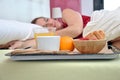 Woman sleeping on her bed with a breakfast Royalty Free Stock Photo