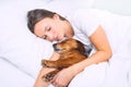 Woman sleeping with her dog. Lovely dachshund dog sleeping with owner. Together with best friend