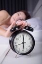 woman sleeping and wake up to turn off the alarm clock in morning Royalty Free Stock Photo