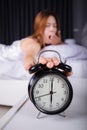 woman sleeping and wake up to turn off the alarm clock in morning Royalty Free Stock Photo