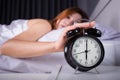 woman sleeping and wake up to turn off the alarm clock in morning Royalty Free Stock Photo