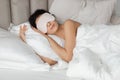 Woman sleeping wearing sleep mask in comfortable bed