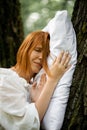 Woman sleeps soundly outdoors. She is lying on a pillow on a tree. Unity with nature, relaxation, recovery concept Royalty Free Stock Photo