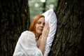 Woman sleeps soundly outdoors. She is lying on a pillow on a tree. Unity with nature, relaxation, recovery concept Royalty Free Stock Photo