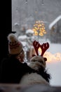 Woman looks out of the window on snowy backyard