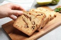 Woman with slice of pear bread at grey table, closeup. Homemade cake Royalty Free Stock Photo