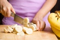 Woman slice ripe banana fruit