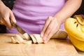 Woman slice ripe banana