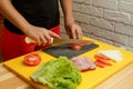 Woman slice tomato. Cooking from fresh vegetables