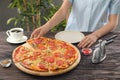 Woman with sliced pepperoni pizza at table
